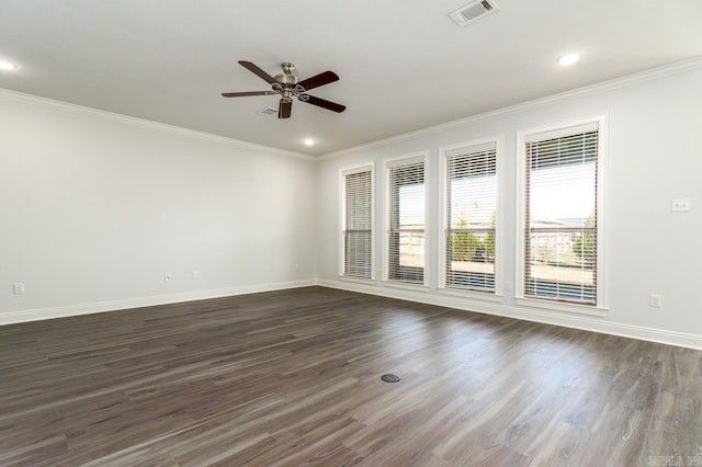 empty room with ceiling fan, a wealth of natural light, dark hardwood / wood-style floors, and ornamental molding