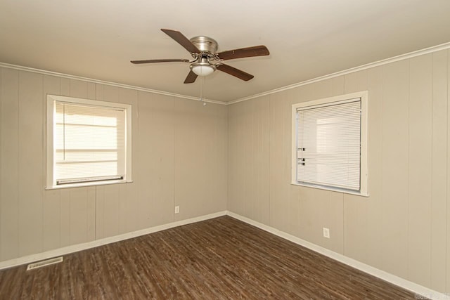 empty room with dark hardwood / wood-style floors, ceiling fan, and ornamental molding