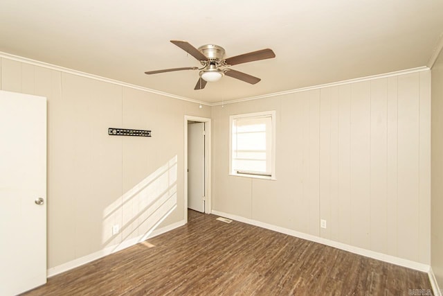 unfurnished room with ceiling fan, crown molding, and dark wood-type flooring