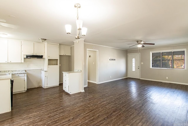 kitchen with white cabinetry, crown molding, pendant lighting, decorative backsplash, and ceiling fan with notable chandelier