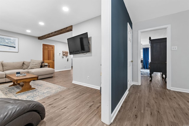 living room with beamed ceiling and wood-type flooring