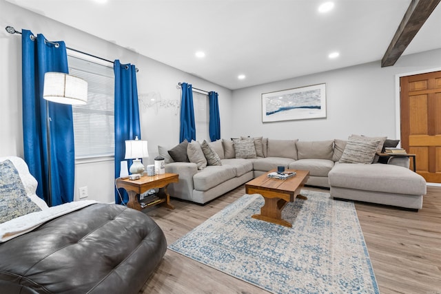 living room with light hardwood / wood-style flooring and beamed ceiling