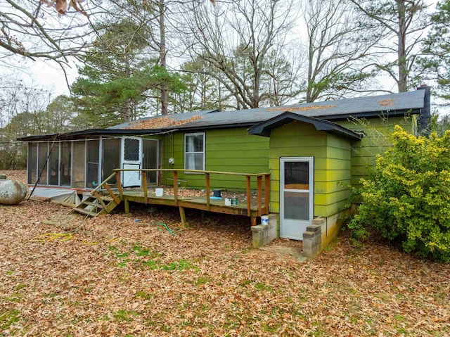 back of property with a deck and a sunroom