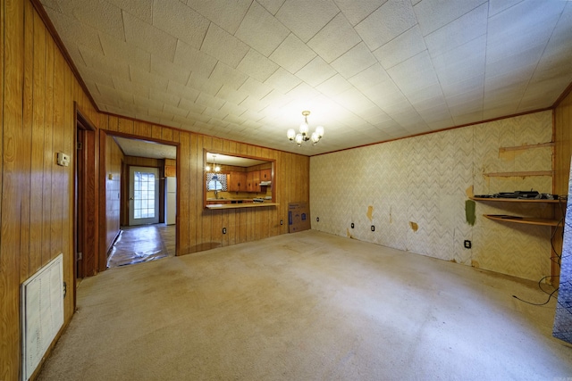 unfurnished living room featuring carpet and a notable chandelier