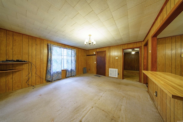 interior space with wooden walls and ceiling fan with notable chandelier