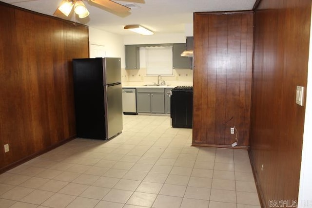 kitchen with wooden walls, dishwasher, range, and stainless steel refrigerator