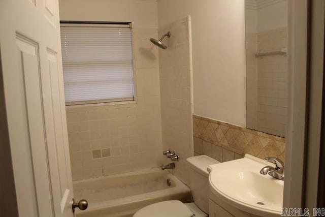 full bathroom featuring backsplash, vanity, tiled shower / bath, and toilet