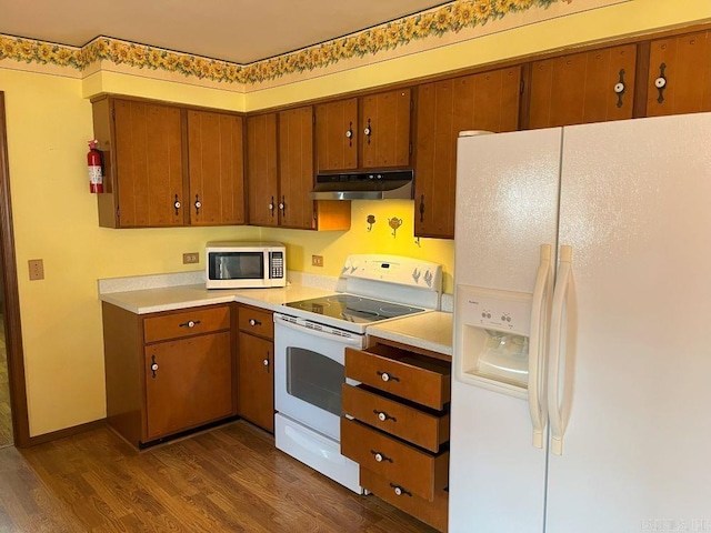 kitchen with dark hardwood / wood-style flooring and white appliances