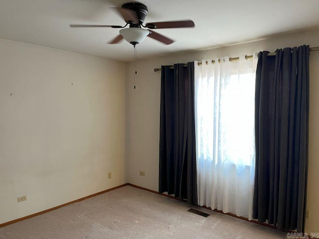 carpeted spare room with ceiling fan