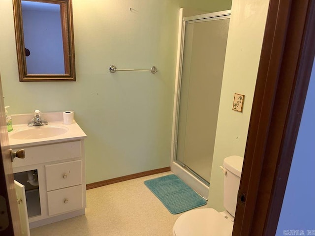 bathroom with vanity, toilet, and a shower with door