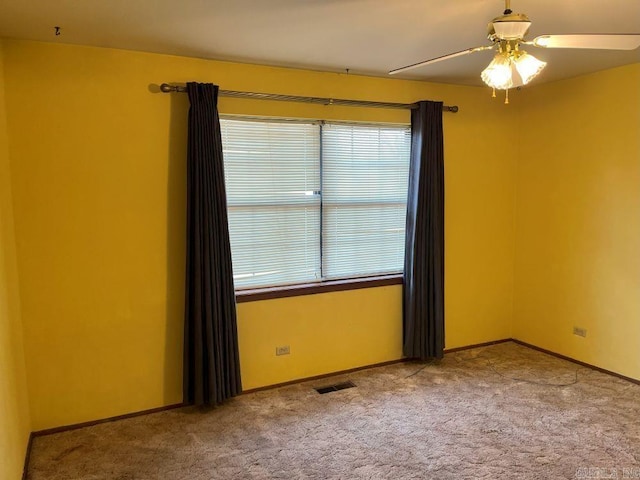 carpeted spare room with ceiling fan