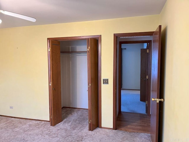 unfurnished bedroom with ceiling fan, a closet, and light colored carpet