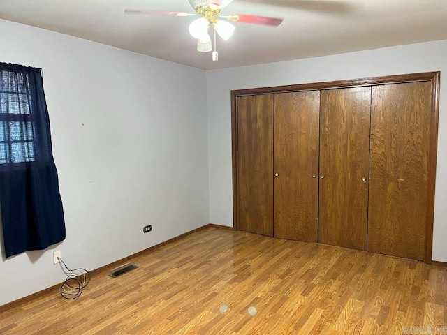 unfurnished bedroom with light wood-type flooring, a closet, and ceiling fan