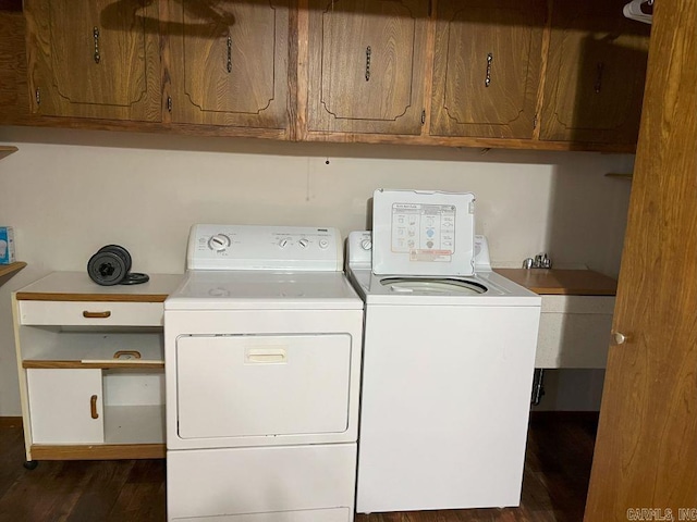 laundry room with cabinets, dark hardwood / wood-style flooring, and washing machine and clothes dryer