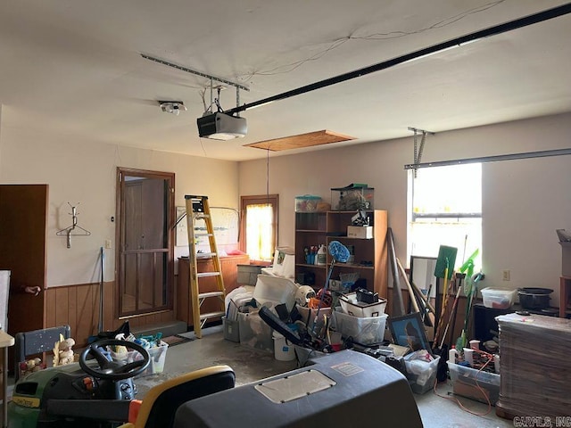 garage with wood walls and a garage door opener