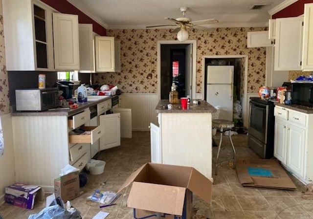 kitchen with ceiling fan, white cabinets, black appliances, and ornamental molding