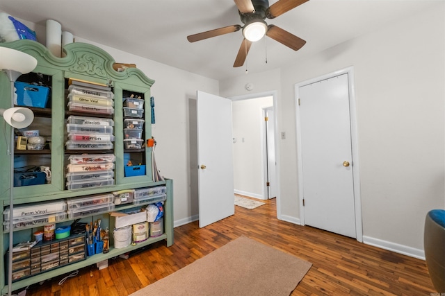 game room with ceiling fan and dark wood-type flooring