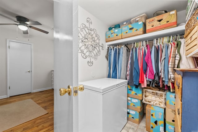 laundry room with ceiling fan and light hardwood / wood-style flooring