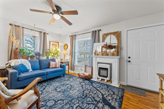 living room with heating unit, hardwood / wood-style flooring, a wealth of natural light, and ceiling fan