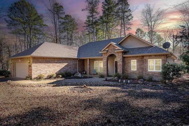 ranch-style home with a porch and a garage