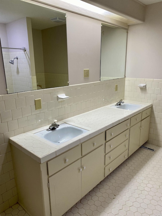 bathroom with tile patterned floors, vanity, and tile walls