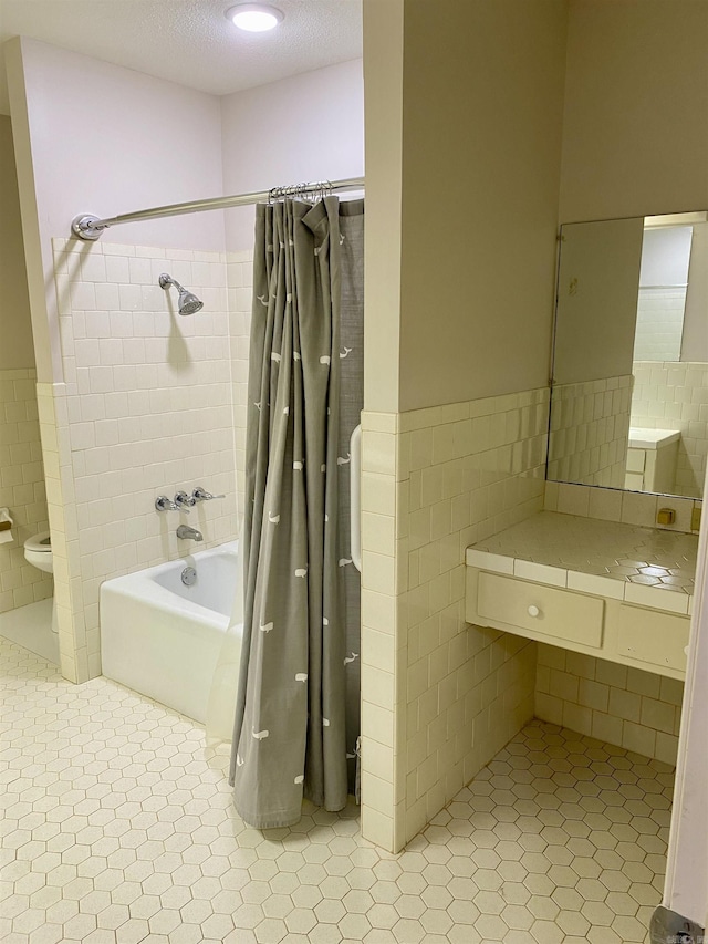 bathroom with tile patterned floors, toilet, tile walls, and shower / tub combo with curtain