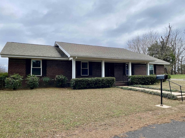 ranch-style house with covered porch and a front yard