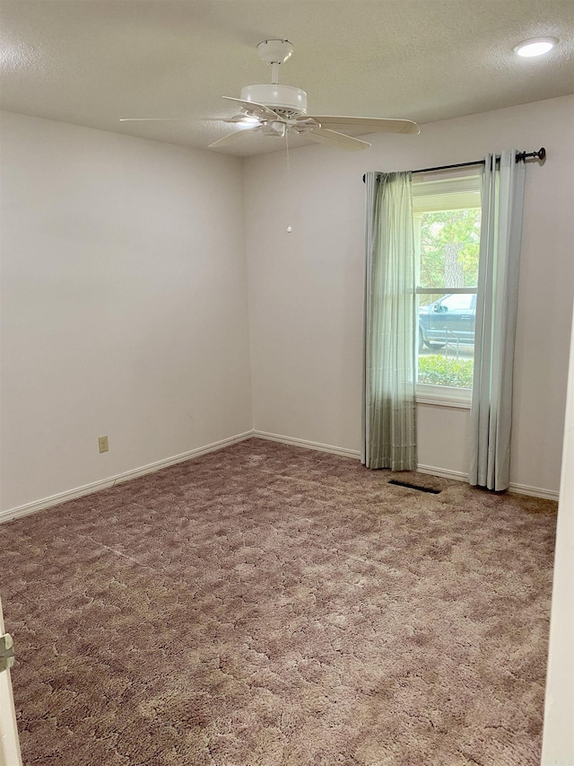 carpeted spare room with ceiling fan and a textured ceiling