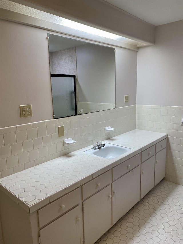 bathroom featuring tile patterned floors, vanity, and tile walls