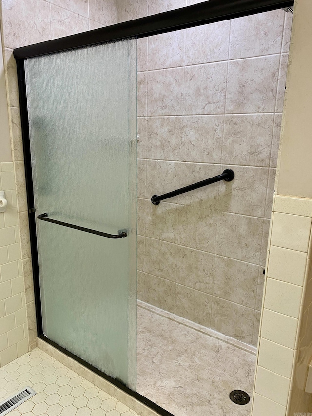 bathroom featuring a shower with shower door