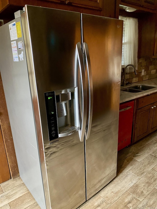 kitchen featuring backsplash, stainless steel fridge with ice dispenser, and sink