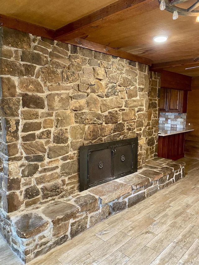 room details with backsplash, wood-type flooring, beam ceiling, wooden ceiling, and a fireplace