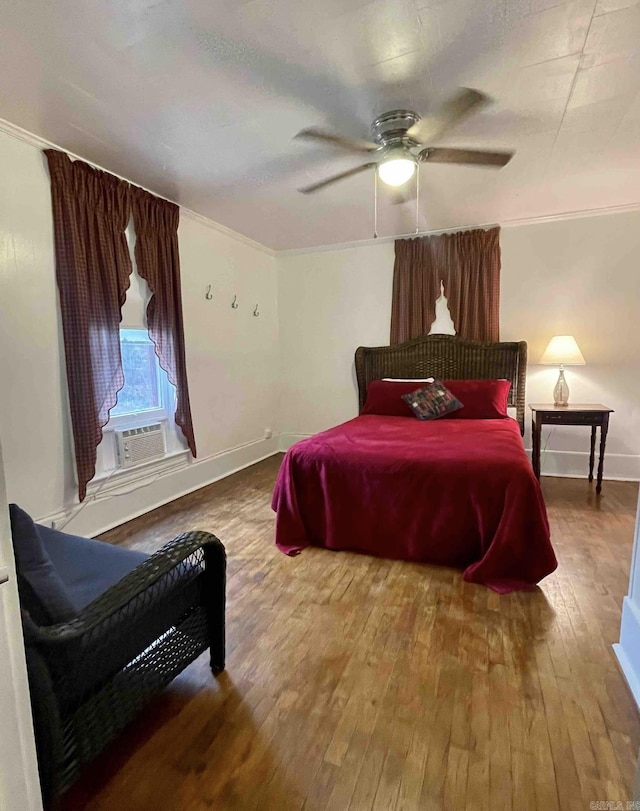 bedroom featuring cooling unit, hardwood / wood-style flooring, ceiling fan, and ornamental molding