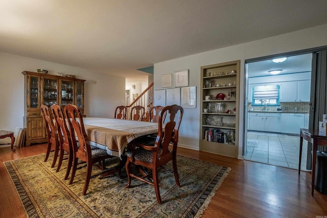 dining room featuring built in shelves and wood-type flooring