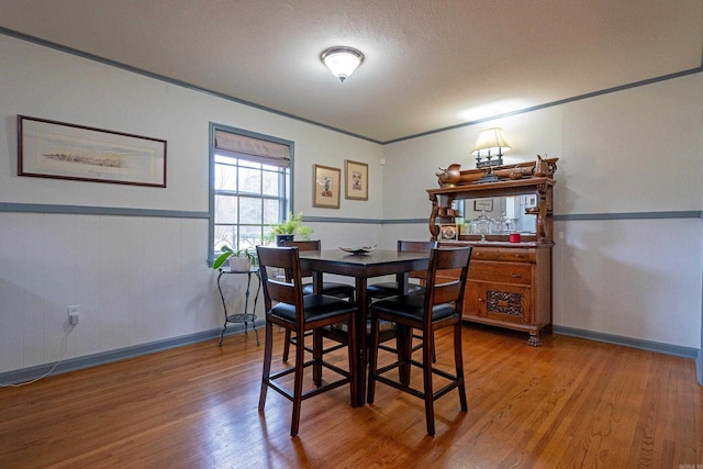 dining room with hardwood / wood-style floors and crown molding