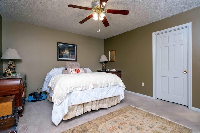 carpeted bedroom featuring ceiling fan and a textured ceiling