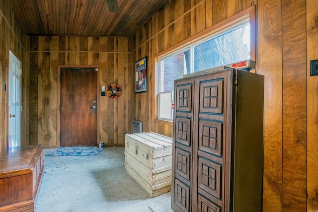 hall featuring wooden ceiling and wooden walls