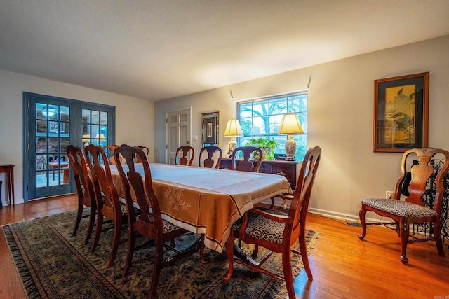 dining area with french doors and light hardwood / wood-style floors