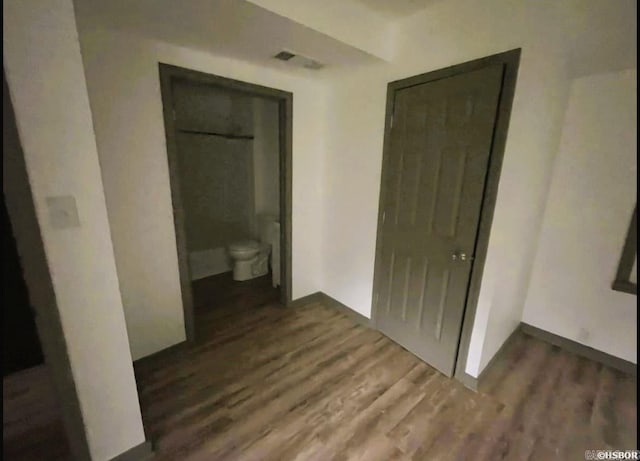 corridor with dark hardwood / wood-style flooring