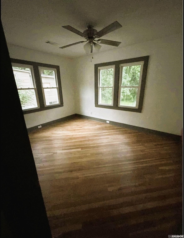 empty room with hardwood / wood-style flooring and ceiling fan