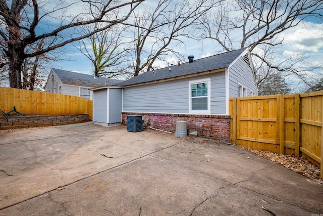 rear view of property featuring central AC unit and a patio area