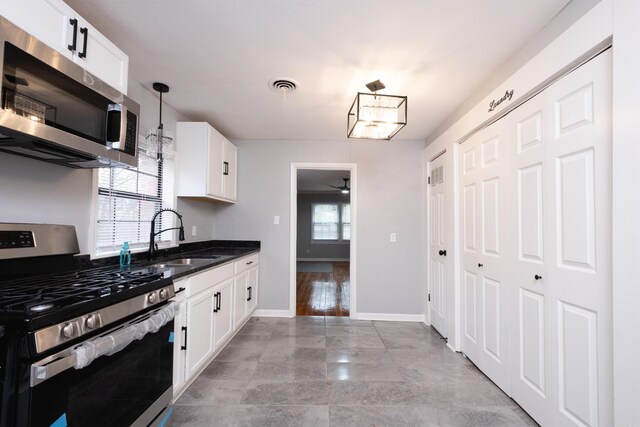 kitchen featuring white cabinetry, sink, plenty of natural light, pendant lighting, and appliances with stainless steel finishes