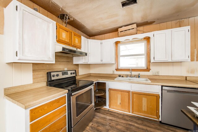 kitchen featuring white cabinetry, sink, appliances with stainless steel finishes, and dark wood-type flooring