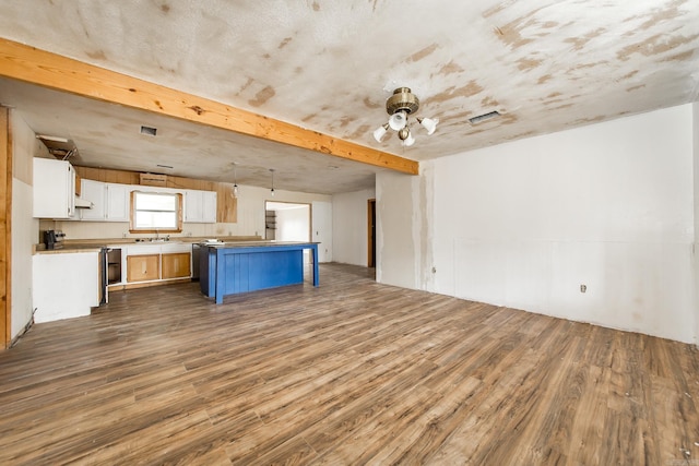 kitchen featuring white cabinetry, sink, range, a kitchen island, and hardwood / wood-style flooring