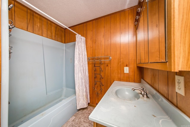 bathroom with vanity, a textured ceiling, wooden walls, and shower / tub combo with curtain