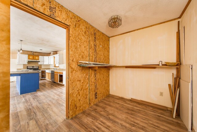 kitchen featuring a kitchen island, hardwood / wood-style floors, a breakfast bar area, white cabinets, and appliances with stainless steel finishes