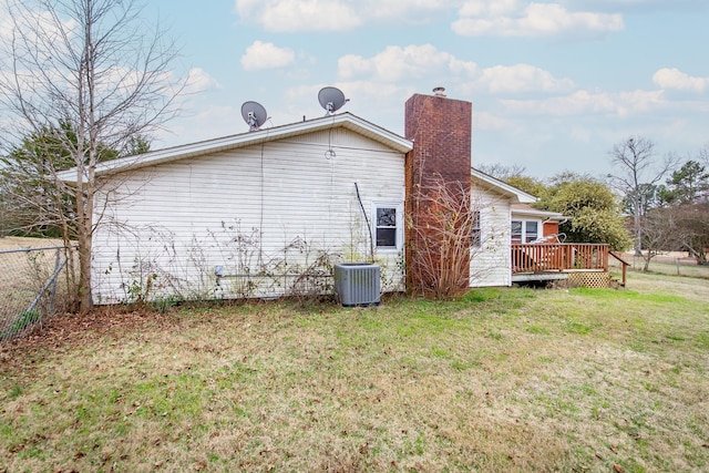 back of house with a lawn, a wooden deck, and central air condition unit