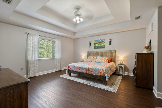 bedroom featuring a tray ceiling, ceiling fan, and dark hardwood / wood-style floors