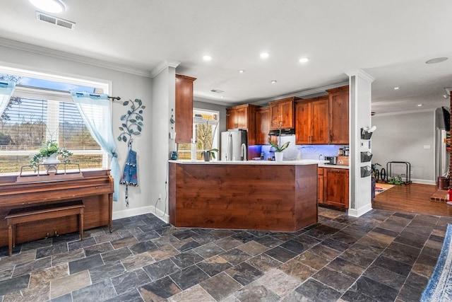 kitchen with kitchen peninsula, stainless steel fridge, and ornamental molding