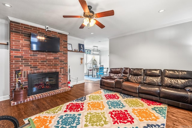 living room featuring wood-type flooring, a brick fireplace, and crown molding